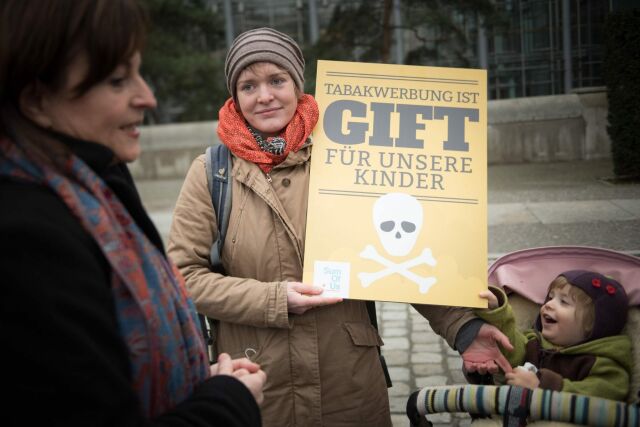 Marlene Mortler, Bundesdrogenbeauftragte (links) mit Aktivistin für das Tabakwerbeverbot und Kind